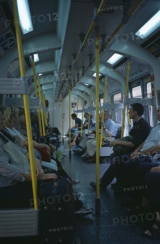 20059178 ENGLAND  London The London Underground. Interior view through the train carriage with passengers sitting on seats.