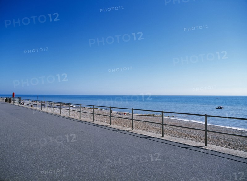 20059214 ENGLAND East Sussex Bexhill on Sea View from path across railings towards shingle beach and calm blue sea.