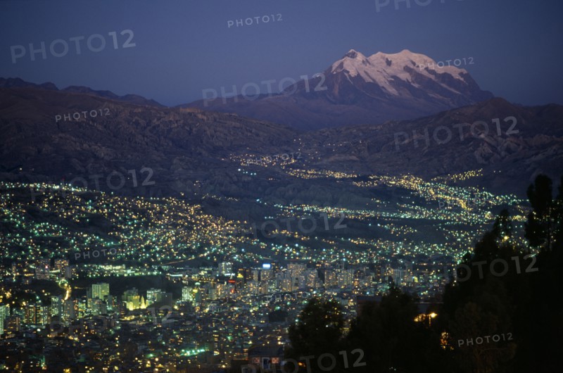 20054568 BOLIVIA  La Paz Illuminated cityscape and snow capped peak of Mount Illimani at dusk.
