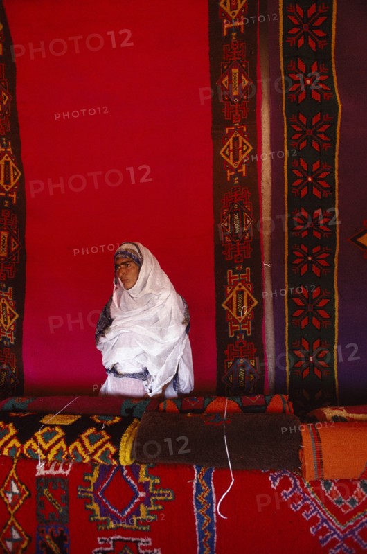 WESTERN SAHARA, Markets, Textiles, Woman with traditional carpets.