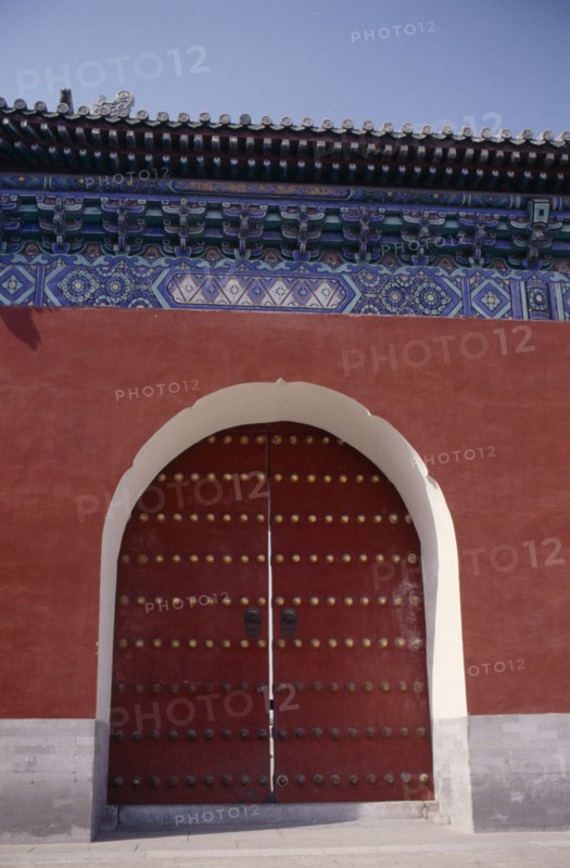 CHINA, Beijing, Temple of Heaven.  Detail of gateway set into red painted wall with decorative blue tiling above.
