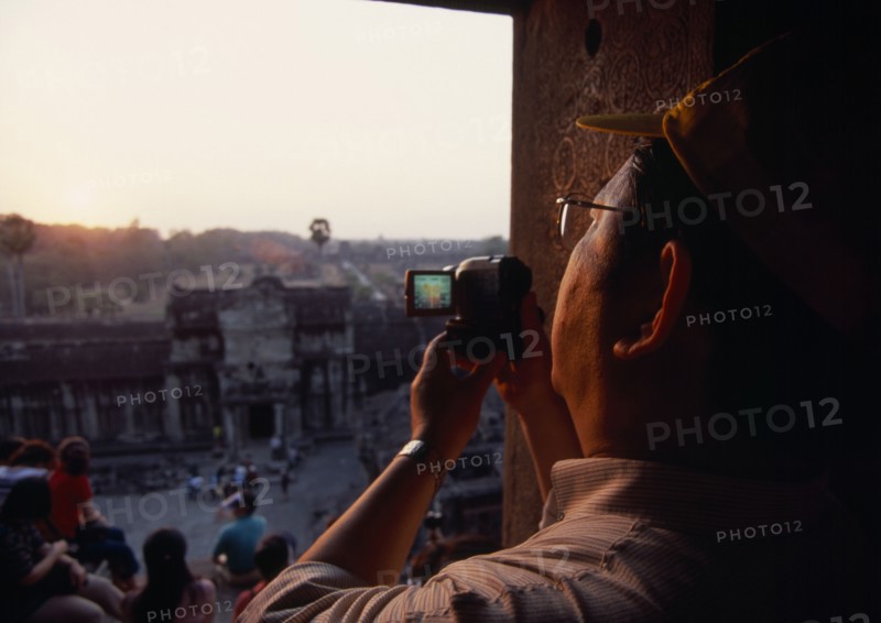CAMBODIA, Siem Reap Province, Angkor Wat, Tourist with video camera.