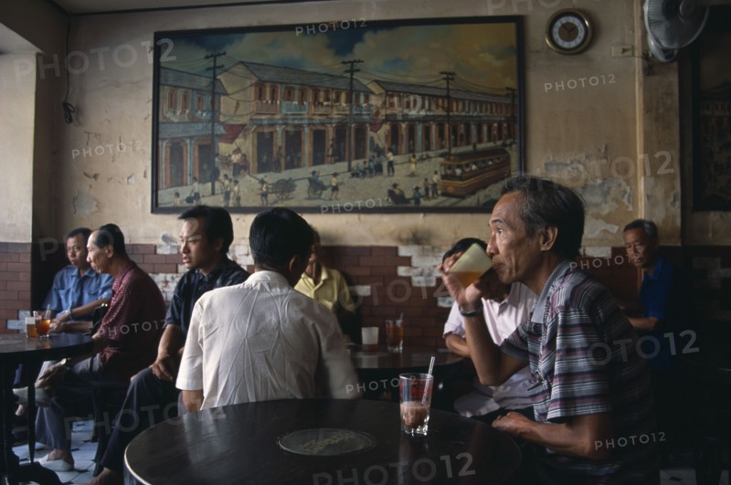 THAILAND, South, Bangkok, Chinatown teahouse with male locals seated in front of an old painting of Chinatown