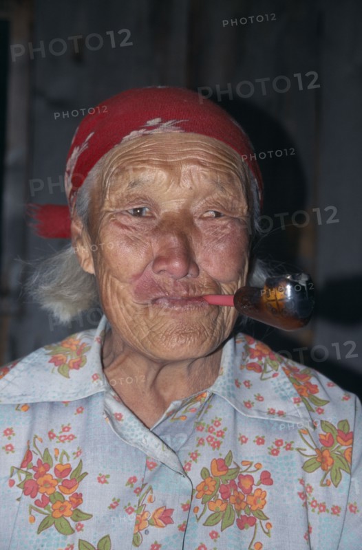 RUSSIA, Siberia, Lake Baikal, Portrait of elderly Buryat woman smoking pipe.