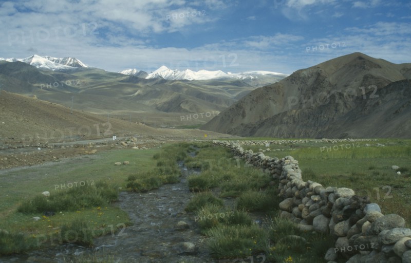 INDIA, Ladakh, Himalayas, Mountain landscape with rocky stream through valley floor in foreground.