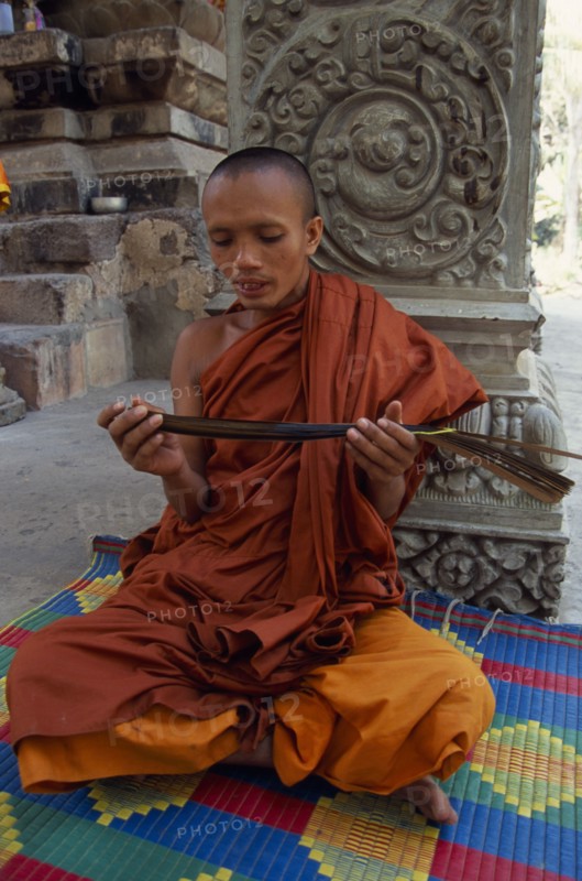 CAMBODIA, Siem Reap Province, Angkor Thom, Buddhist monk chanting from Sanskrit prayers inscribed on palm leaf.