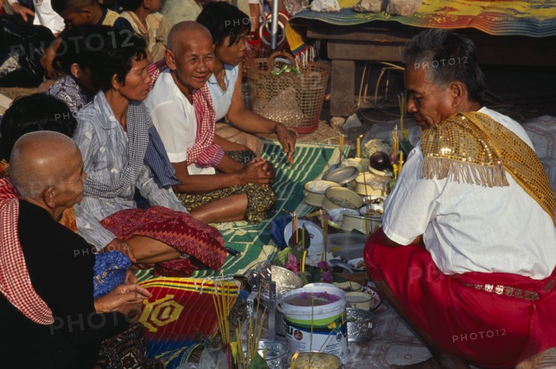 CAMBODIA, Siem Reap, Angkor Wat, Shaman at ceremony smelling the offerings of food brought by the Khmer people