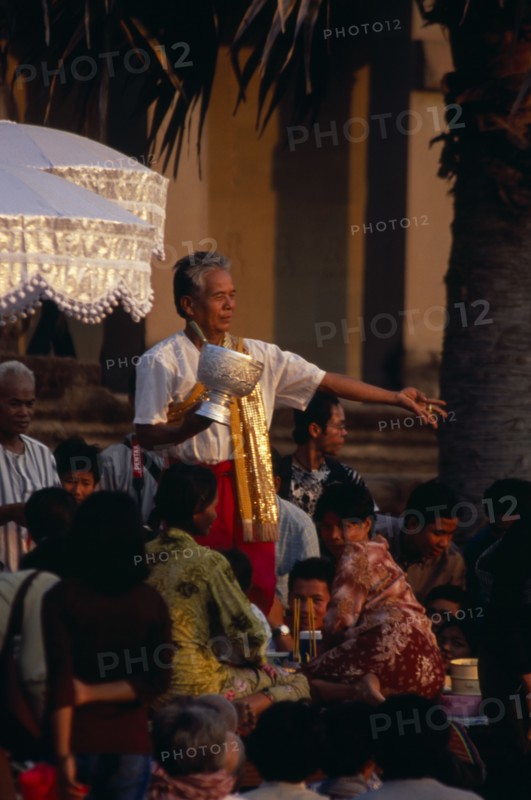 CAMBODIA, Siem Reap, Angkor Wat, Shaman at ceremony blessing devotees with the holy water