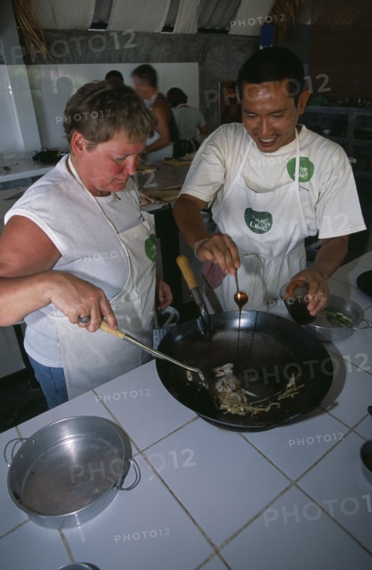 THAILAND, Krabi, Koh Lanta Yai, Cookery class at Time For Lime on Klong Dao beach. Instructor with tourist using a wok