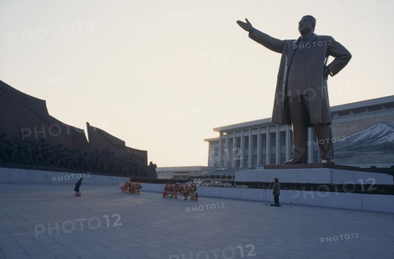 NORTH KOREA, Pyongyang, "Woman bowing in respect in front of statue of Kim II Sung, the Grand Monument."