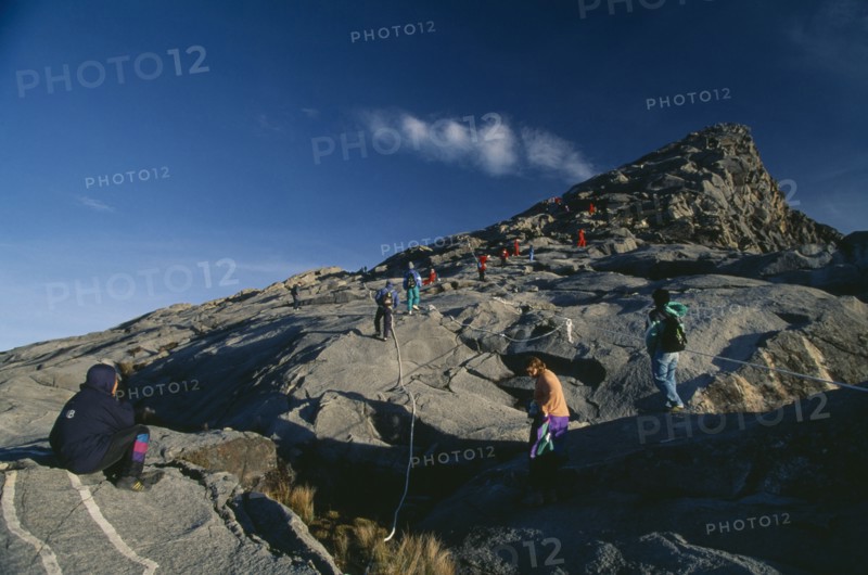 MALAYSIA, Borneo, Sabah, Tourists approaching Lows Peak the summit of Mount Kinabalu.