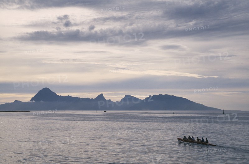 PACIFIC ISLANDS, French Polynesia, Tuamotu Islands, Ringiroa.  Kayak on water in low light with silhouetted island coastline.