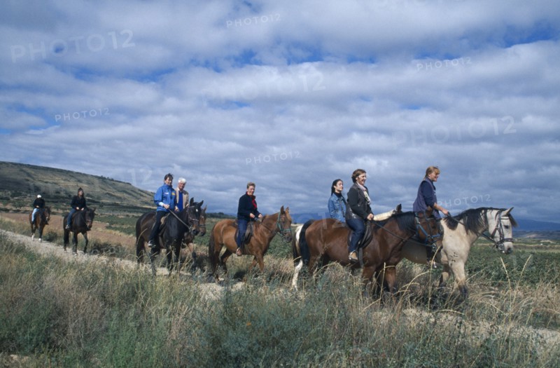 SPAIN, La Rioja, Tourist group trekking on horseback through rural landscape.