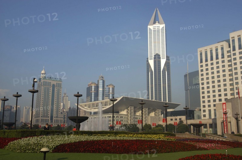 CHINA, Shanghai, Modern city skyline seen over formal garden in the foreground