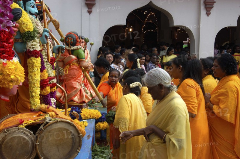 SINGAPORE, , Women standing beside a colourful shrine decorated with flower garlands at an Indian Temple