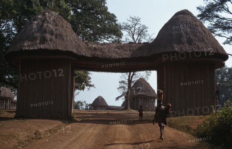 CAMEROON, Bafut, Thatched gateway with woman and children below.