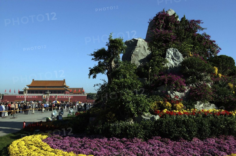 CHINA, Beijing, Tiananmen Square, Gate of Heavenly Peace or Tiananmen. View over rockery and flowerbeds toward crowds gathered outside the gate building