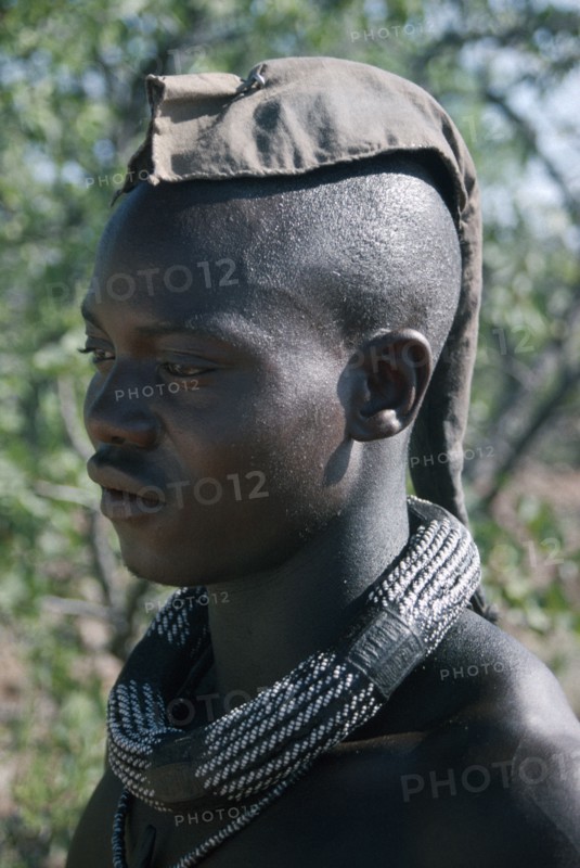 NAMIBIA, Skeleton Coast, Hoarusib Valley, Kaokoland.  Portrait of Himba man.  Cloth covering head denotes that he is married.