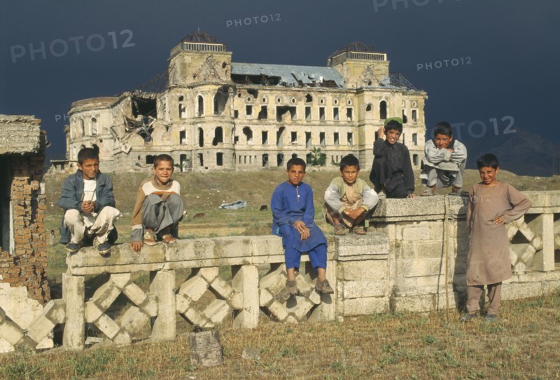AFGHANISTAN, Kabul, Group of boys in front of heavily damaged Kabul Palace.