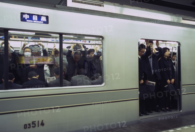 JAPAN, Honshu, Tokyo, Subway train at a platform with passengers crowded on