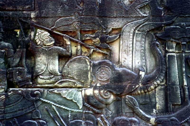 CAMBODIA, Angkor, The Bayon. Carved detail of the pyramid temple built in the centre of the ancient city of Angkor Thom depicting figure with spear riding an elephant