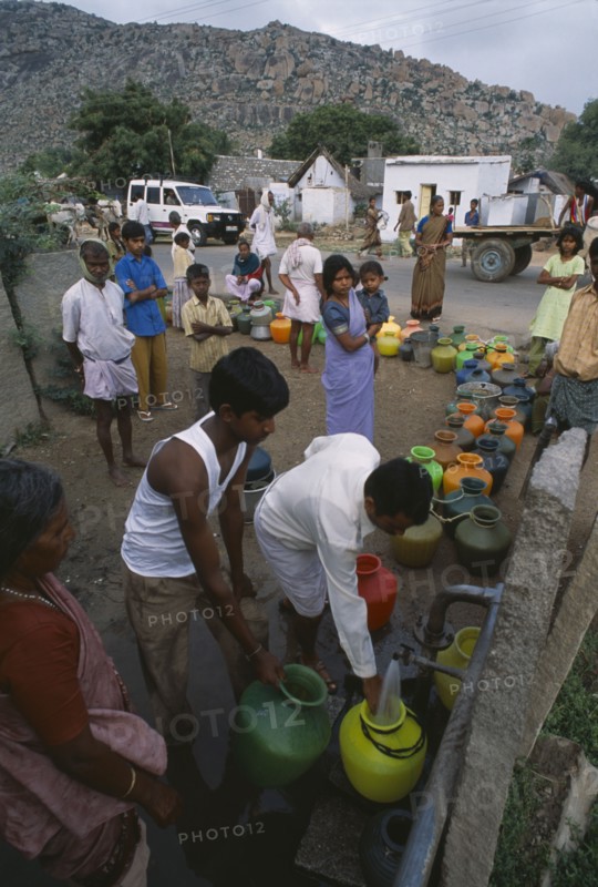 INDIA, Andhra Pradesh, Anantapur, People queuing with their plastic water pots to collect water from the common village tap.