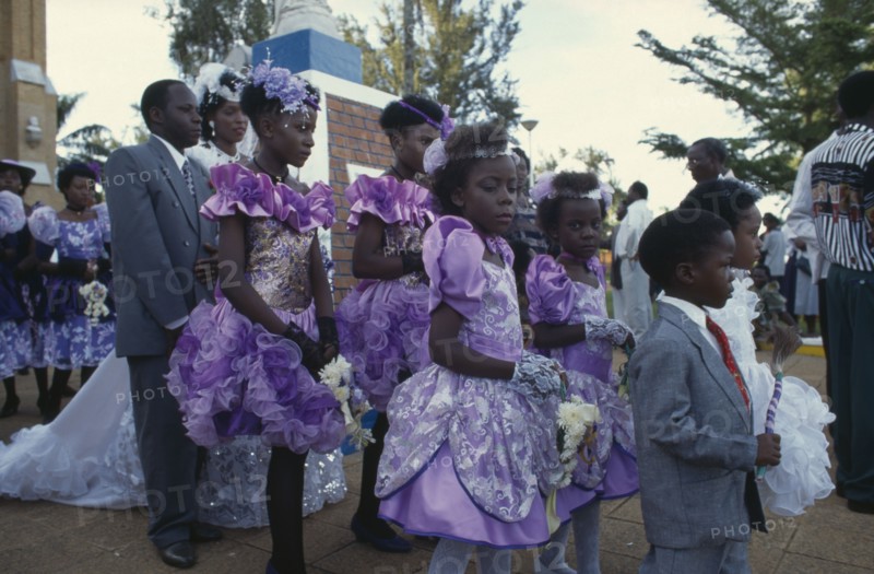 UGANDA, Rubanga, Christian wedding ceremony.  Bride and groom with bridesmaids and page boys outside cathedral.