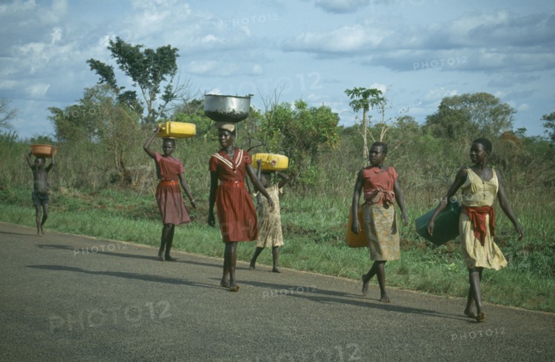 UGANDA, Gulu, Acholi girls walking down the road some carrying baskets on their heads