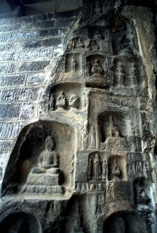 CHINA, Henan, Near Luoyang, Ancient Longmen caves. Images of Buddha and his disciples carved in to the cliff wall