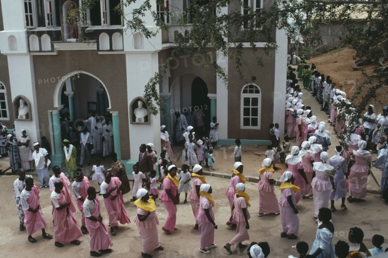 GHANA, Religion, Easter, Men and women in traditional pink dress leaving the Easter Sunday service