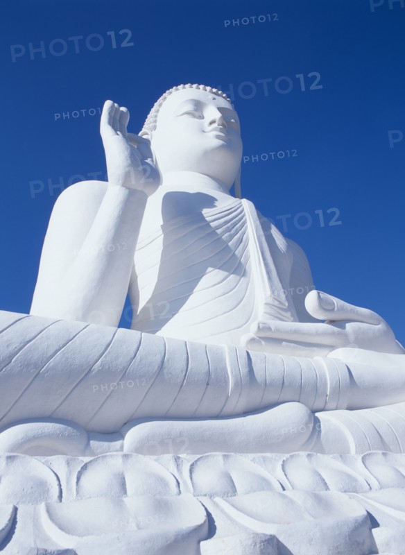 SRI LANKA, Mihintale, Angled view of large white seated Buddha seen from below looking up.