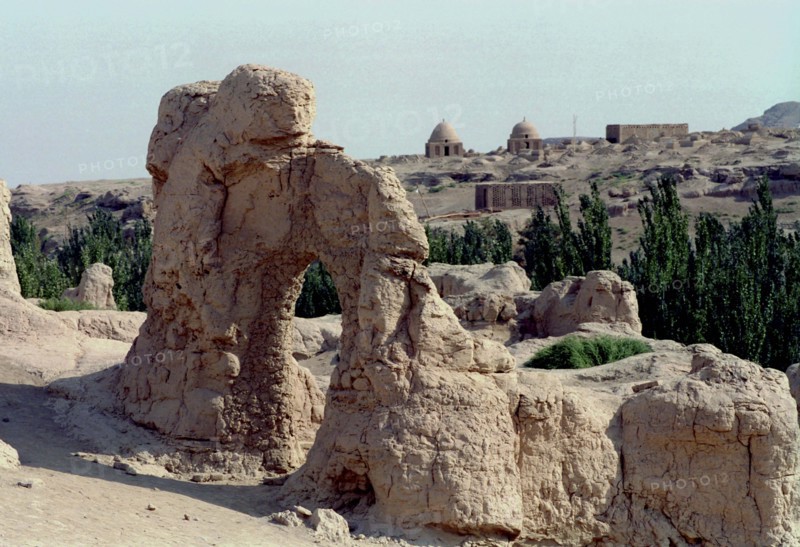 CHINA, Xinjiang, Turpan, View over the Ancient ruins in desert landscape toward distant buildings