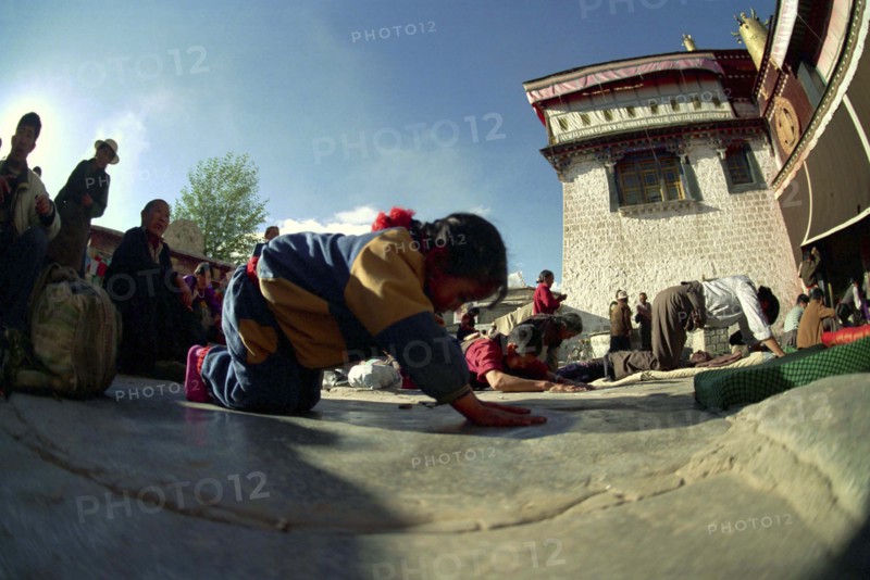 CHINA, Tibet, Lhasa, Wide angle view of  people prostrating themselves outside the Jokhang Temple
