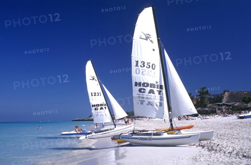 CUBA, Varadero, View along white sandy beach with sail boats at the waters edge