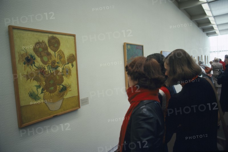 HOLLAND, North, Amsterdam, Visitors inside the Van Gogh Museum looking at painting of Sunflowers.
