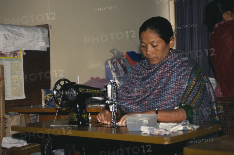 BANGLADESH, Dhaka, Tribal lady working at sewing machine.