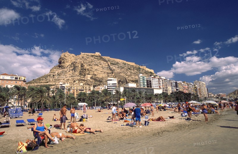 SPAIN, Alicante, Busy beach scene with clifftop castle beyond