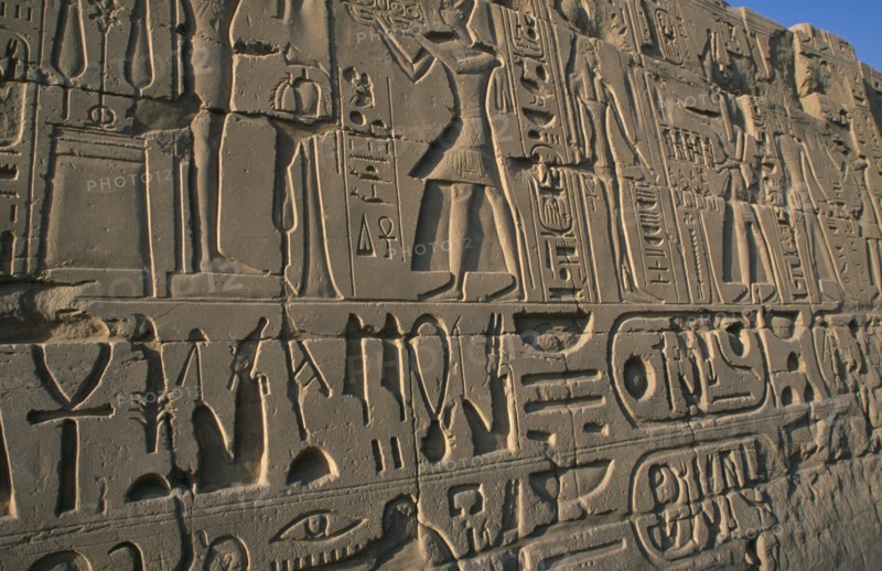EGYPT, Nile Valley, Karnak, Precinct of Amun.  Detail of relief carving and hieroglyphics along wall of building.
