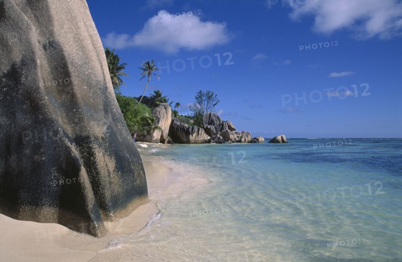 SEYCHELLES, La Digue Island, Anse Source D’Argent. View from behind large rock boulders on golden sandy beach looking along coastline