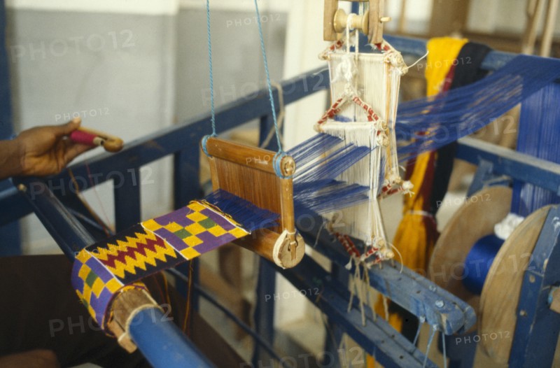 GHANA, Kumasi, Weaving contemporary kente cloth designs.