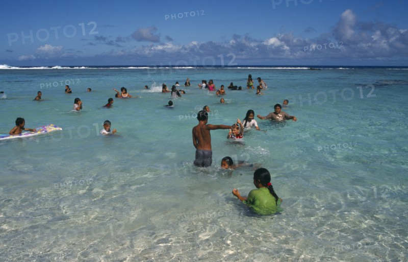 PACIFIC ISLANDS, Polynesia, Cook Islands, Atiu.  Girls swimming in the harbour.