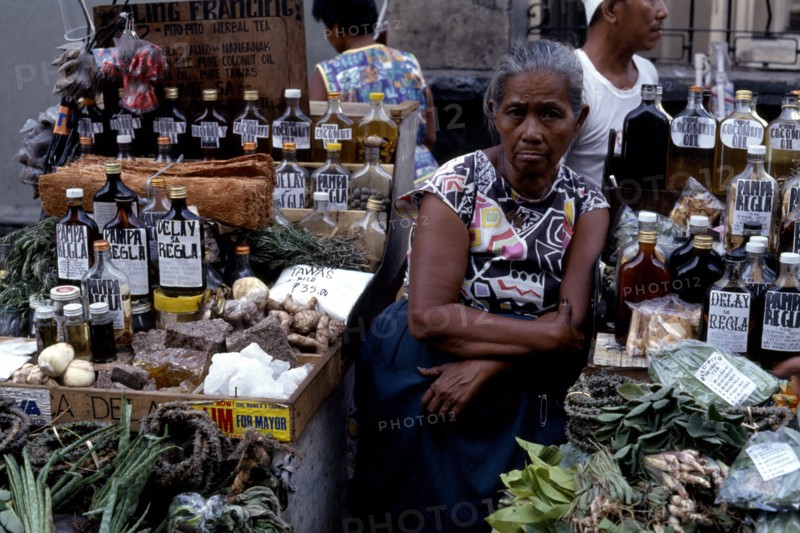 PHILIPPINES, Luzon, Manila, Woman selling various medicines on market stall.