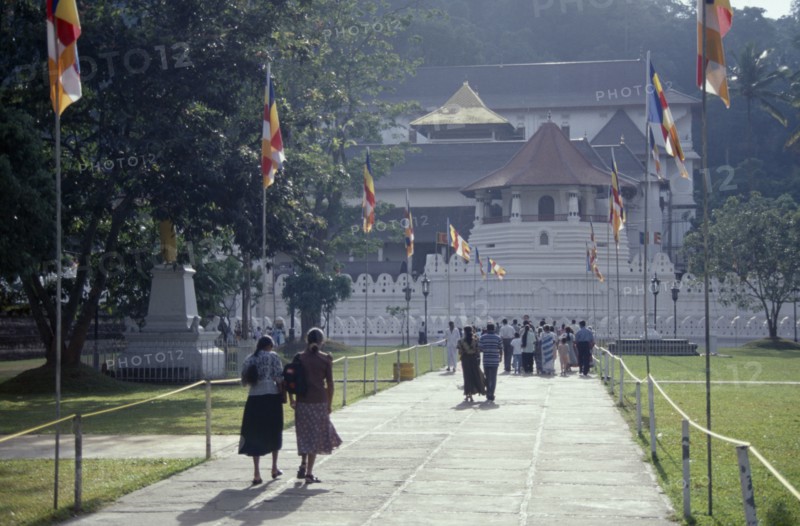 SRI LANKA, Kandy, People walking down flag lined walkway toward the Temple of the Tooth
