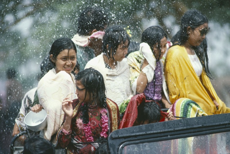 MYANMAR, Mandalay, Thingyan Buddhist Water Festival.  Group of young girls in back of truck drenched in spray of water.