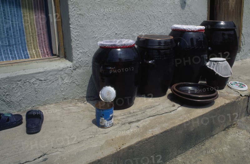 SOUTH KOREA, Sokcho, Ceramic jars of kimchi traditional pickled vegetables standing on doorstep of house in east coast fishing port.
