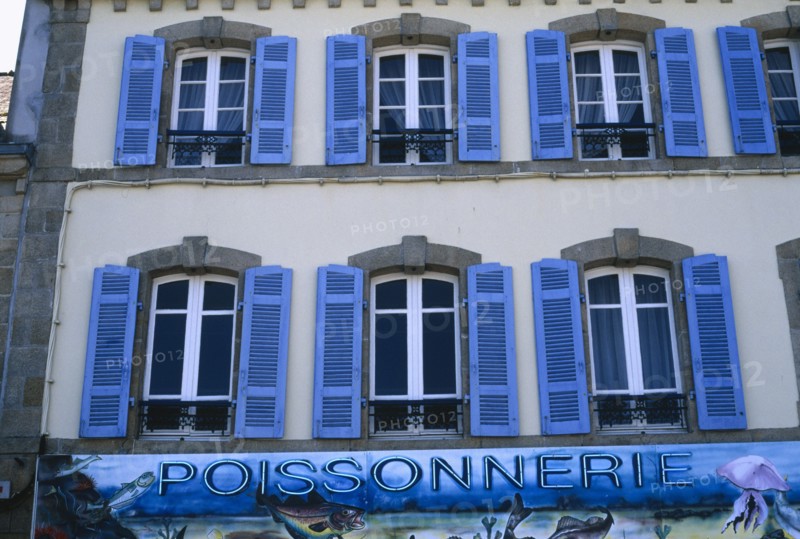 FRANCE, Brittany, Finistere, Douarnenez. Blue shuttered windows over Poissonnerie sign.