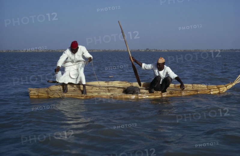 CHAD, Lake Chad, Two Buduma tribesmen fishing in a reed boat on the lake