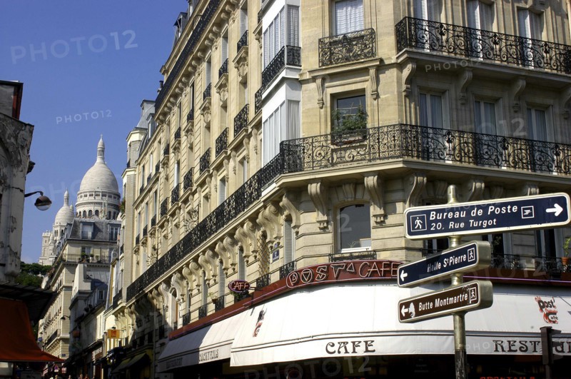 FRANCE, Ile de France, Paris, Corner cafe  and street signs with the domes of the Sacre Coeur in the distance