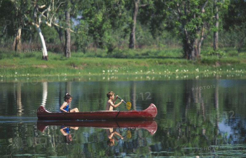 AUSTRALIA, Northern Territory, Children canoeing on Annaburroo Billabong near the Arnhem Highway at the Mary River Crossing between Darwin and Kakadu