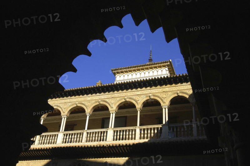 SPAIN, Andalucia, Seville, The Royal Alcazar. Angled view looking up at the roof through an archway